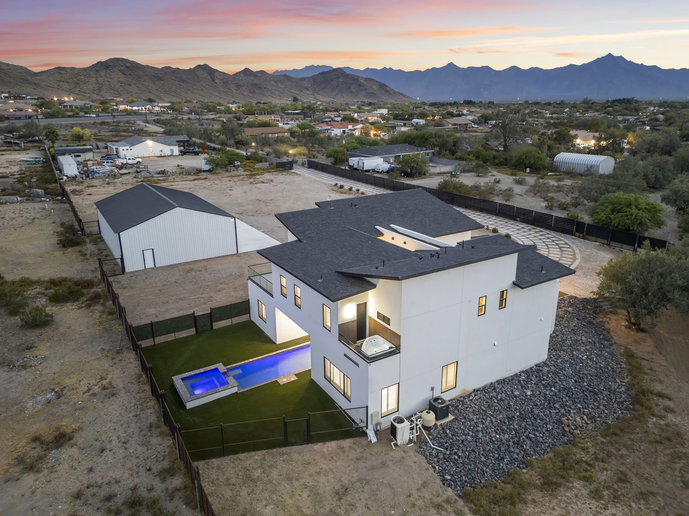 Twilight aerial view of a luxury Scottsdale-area home with pool and mountain backdrop